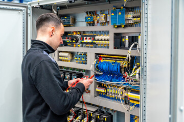 Worker repairing an electrical mechanical system in a factory