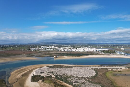 aerial drone view of climate in praia da fuseta in algarve portugal with fields, lakes and beach next to the atlantic ocean and nature