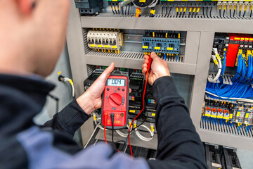 Close-up of a worker repairing an electrical system panel