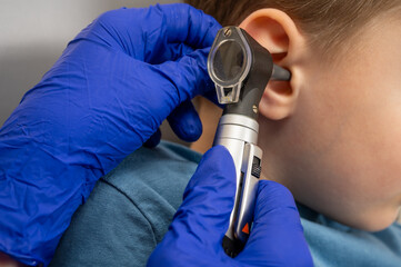 a little boy in the otolaryngologist's office, an examination of the ears by a doctor, an...