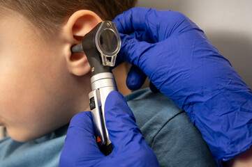a little boy in the otolaryngologist's office, an examination of the ears by a doctor, an...