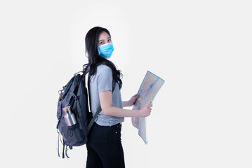 Attractive Asian female tourist Wear a mask to protect against Covid, carry a backpack, look at a travel map on a white background for travel and people's thoughts.