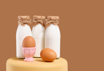 Bottles of fresh farm cow's milk and chicken eggs. Copy space for text. © Dima