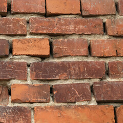 Fragment of a wall made of old red bricks