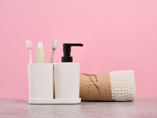 Bathroom set with clean shower towel, toothbrushes and toothpaste. Liquid gel dispenser.