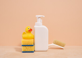 White dirty dishwashing gel dispenser, yellow duck and sponges, cleaning brush.