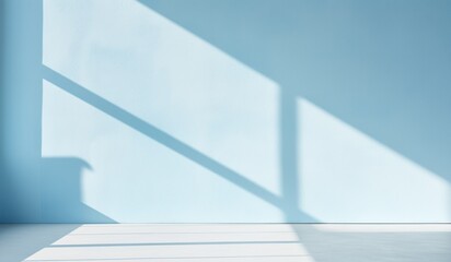 Obraz premium Sunlight casting soft shadows on a minimalist light blue interior wall.