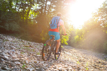 Young man with backpack on the bicycle