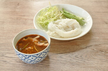 rice noodles with spicy chicken curry sauce and fresh vegetable on plate