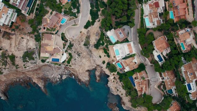 Exclusive and luxurious real estate in port d'andratx, Mallorca, Spain. Aerial of expensive private villas on Mediterranean Coast. Illegal development of park land on the shore