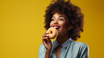 african american woman holding eating donut isolated on yellow background, junk unhealthy food diet concept copy space, Valentine day, sweet tasty life, Valentine day, International Women day, 8 March - obrazy, fototapety, plakaty