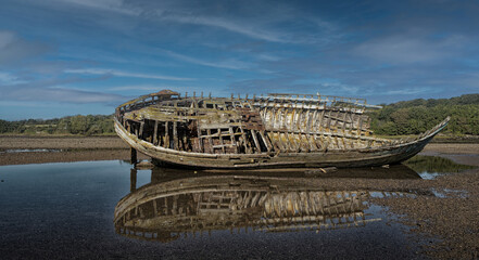 Washed up hulk of wooden fishing boat