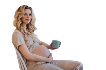 Happy pregnant young blonde caucasian woman sitting at table touching belly feels baby moving inside, female dreaming about newborn baby at home. Healthy pregnancy.