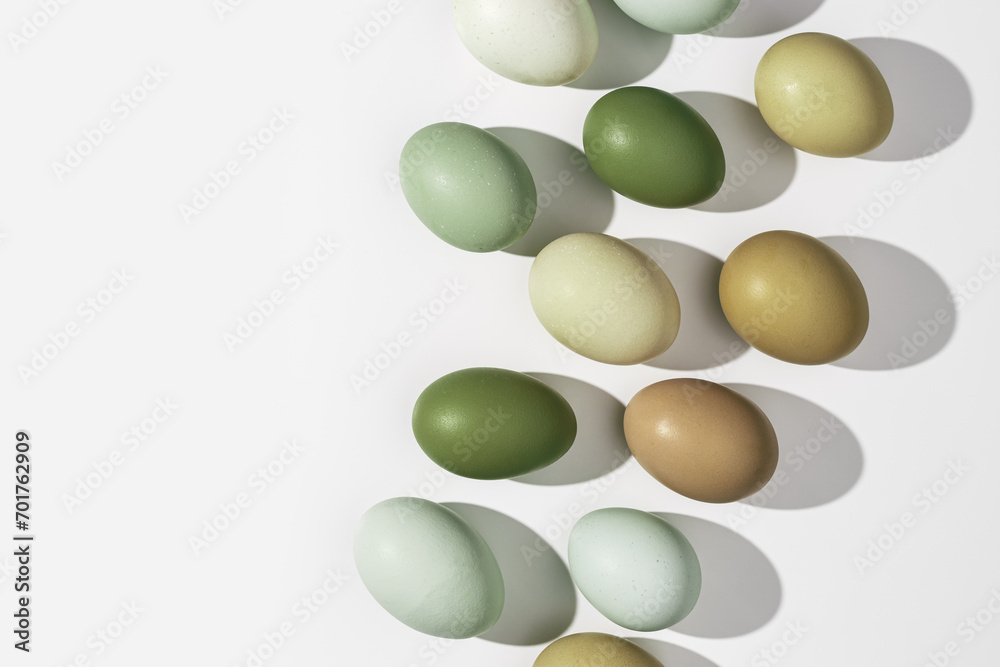 Wall mural natural colorful easter eggs close up, shadow at sunlight, white light background, copy space. chick