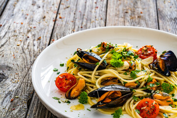 Noodles with mussels on wooden table
