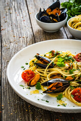 Noodles with mussels on wooden table
