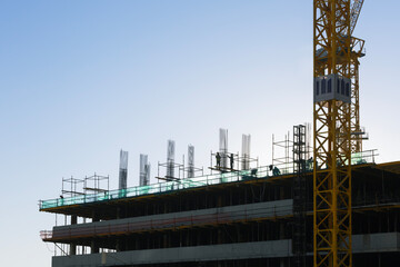 Construction site with construction workers during work on building roof structures. Construction...