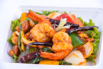 Sweet and sour shimp stir fried on the white dish.
