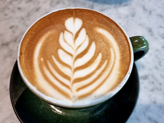 Close-up a cup of hot latte art simple tulip coffee on the table