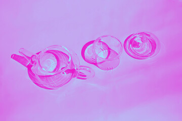 A glass teapot and a cup on the table. minimalism. Shadows. View from the top. duotone