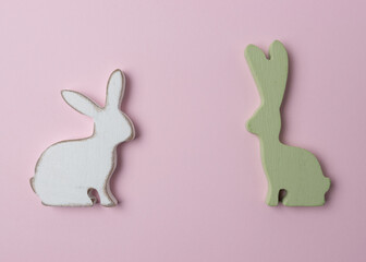 Two Easter bunnies decoration on pink background. Minimal Easter concept.