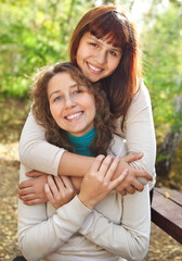Fototapeta premium Young smiling woman with her teen daughter