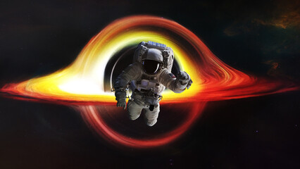 Astronaut in deep space close to the black hole and event horizon. Elements of this image furnished...