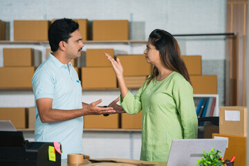 Two business partners or coworkers arguing each other at warehouse or office workplace - concept of...