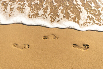 Human footprints on the sand beach. Sunny.