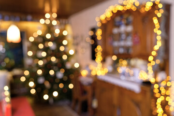 Fototapeta na wymiar Weihnachtliche Raumszene mit Weihnachtsbaum, Lichterketten, Lampen und Kerzen - in abstrakter Unschärfe
