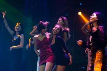 Nightlife and disco dance party concept. Sexy young woman people and friends dancing in night club. music festival. Cheerful Happy fun Asian people dance in night club