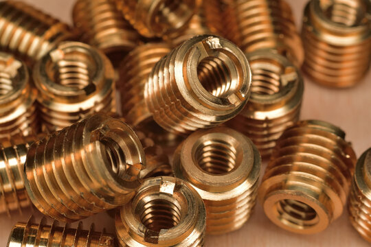 Brass fine thread wood insert. Composite and polymer panels threaded insert. Internal 1/4-20 NC threaded insert. Closeup of brass insert