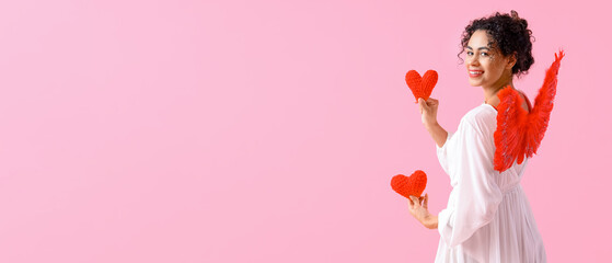 Pretty young woman dressed as Cupid on pink background with space for text. Valentine's Day...