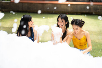 Three sexy girl dance in party. Foam party summer entertainment, Happy smiling sexy young woman on beach foam party