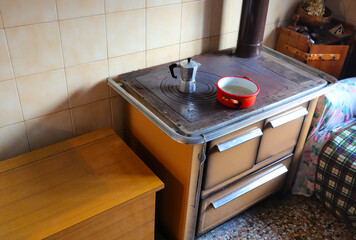 ancient wood stove of an economical kitchen with the moka for preparing coffee at home on the hot...