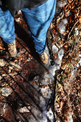 boots and legs with jeans of the adventurous hiker on the impervious path