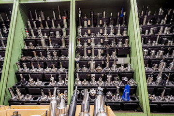 Mills and cutting tools for working on a CNC machine are arranged. in tool racks. - obrazy, fototapety, plakaty