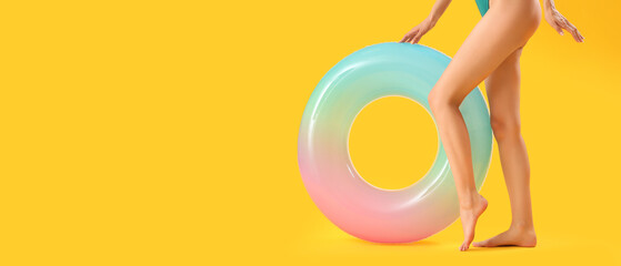 Young woman with inflatable ring on yellow background with space for text - obrazy, fototapety, plakaty