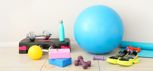 Sports equipment with shoes near light wall in gym