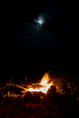 View of a camp fire with a glimpse of the half moon in Mauritius island