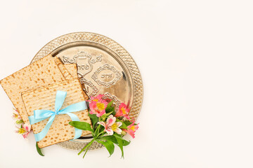 Passover Seder plate with flatbread matza and alstroemeria flowers on white background