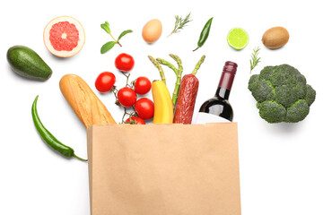 Paper bag with vegetables, fruits and wine bottle on white background