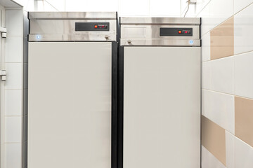 Two refrigerators in restaurant kitchen. Refrigeration equipment for enterprise. Refrigerators in...