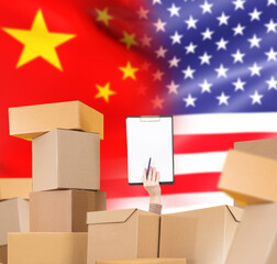 Trade turnover China and USA. Cardboard boxes around hand with clipboard. Trade turnover between...