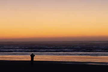 Fototapeta na wymiar People watching the sunset along the beach