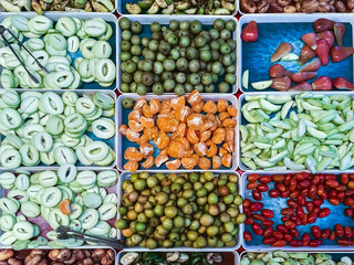 Top view of assorted fruits and pickled fruits on trays for sale in street market, healthy food concept Include high vitamin fruits, fresh fruits, Thai fruits, Street food.Variety fruits as background