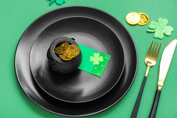Beautiful table setting for St. Patrick's Day celebration on green background