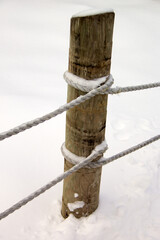 Snowy rope and wood fence