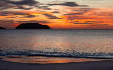 Fototapeta na wymiar Dramatic Sunset Over Water with Island and Shoreline