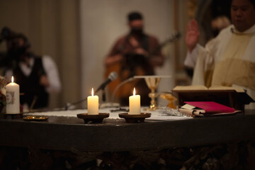 Ein Altar mit Kerzen in einer katholischen Kirche während einer Trauung.  - obrazy, fototapety, plakaty